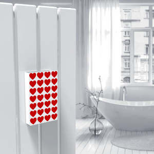 Cover per umidificatore con fantasia a cuori rossi, appeso a un termoarredo ad acqua bianco