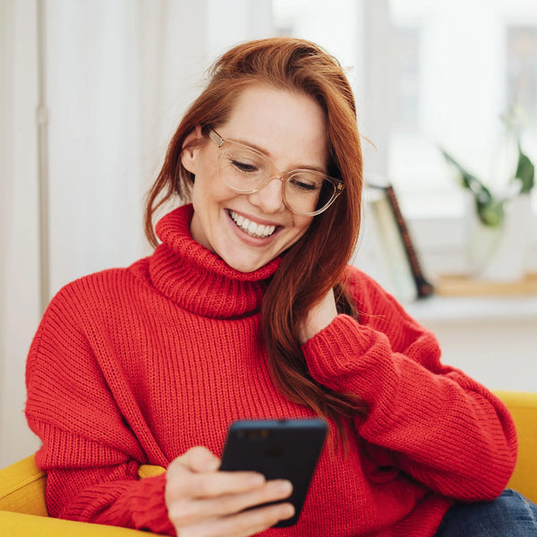 ragazza che sorride con smartphone in mano