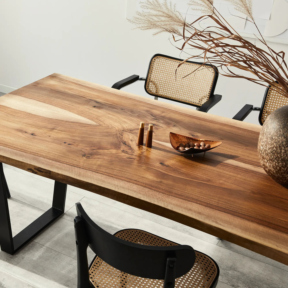 immagine di un tavolo di legno stile moderno sedie in paglia e rami secchi in vaso centrotavola