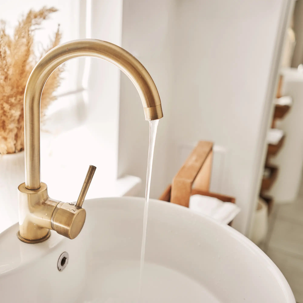 immagine di un rubinetto oro satinato in un bagno moderno